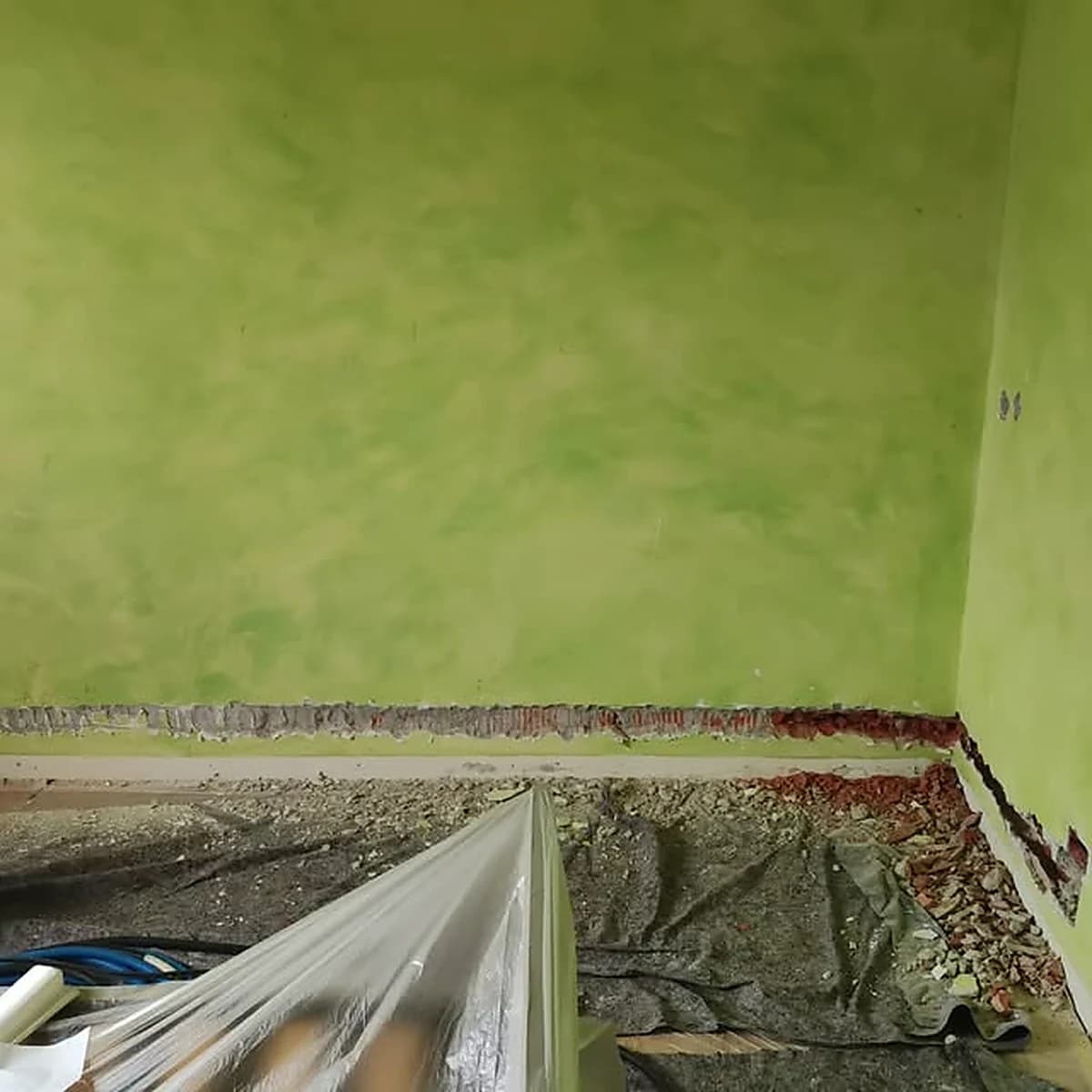 Parete verde a velatura in corso di lavorazione con pavimento telato