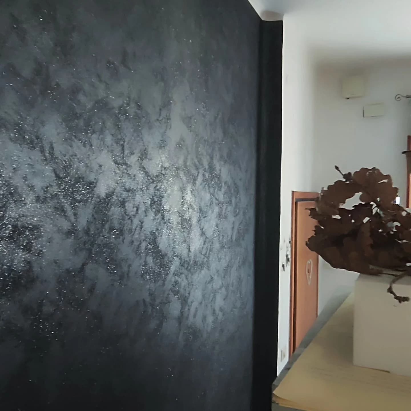 Parete interna con finitura decorativa nera dall'effetto metallico e materico